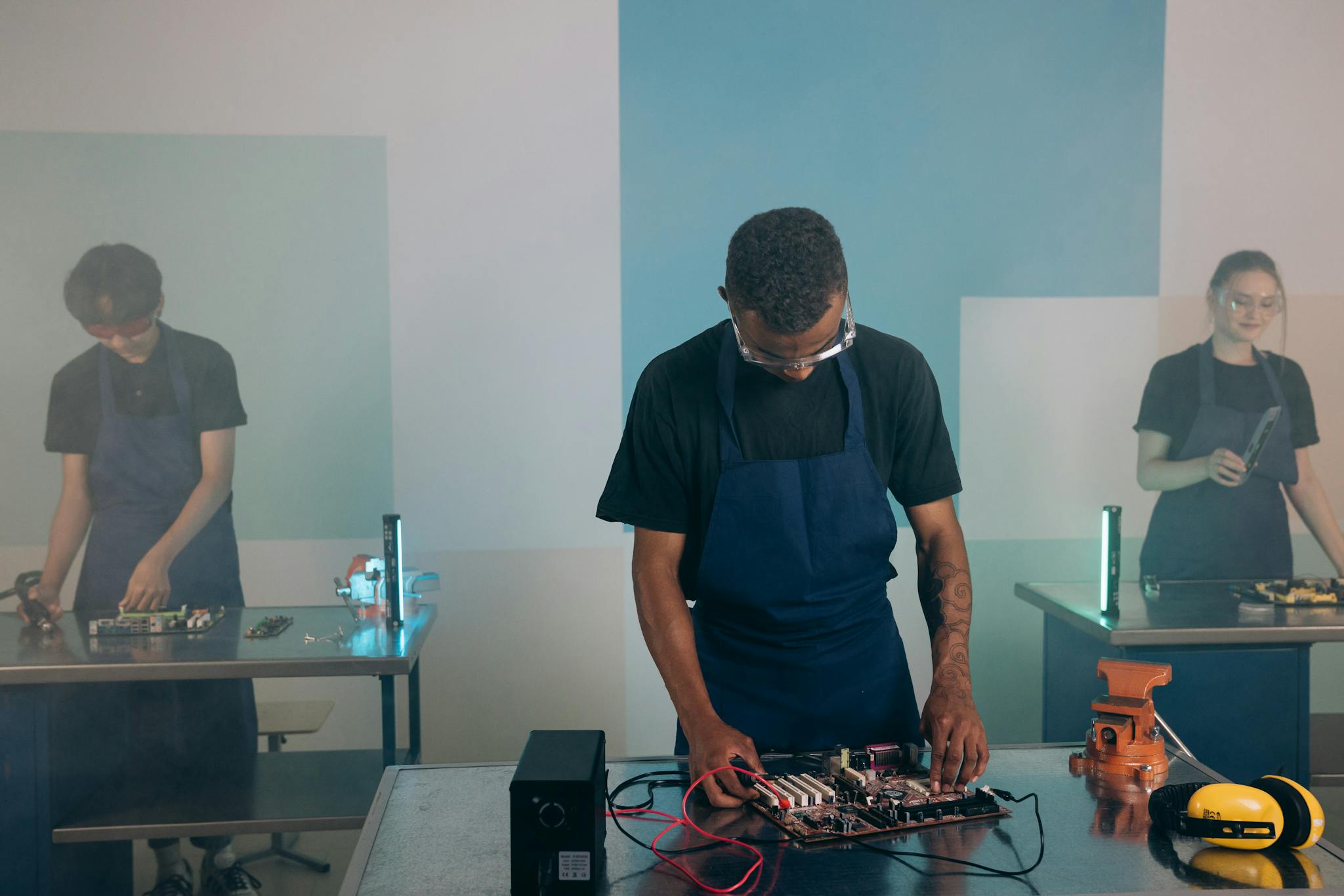 Engineers collaborate on electronic projects in a modern workshop setting.